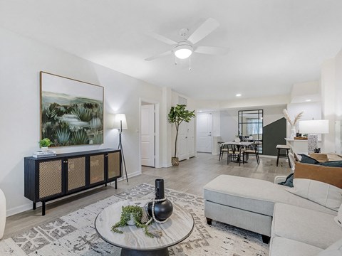 a living room with furniture and a ceiling fan